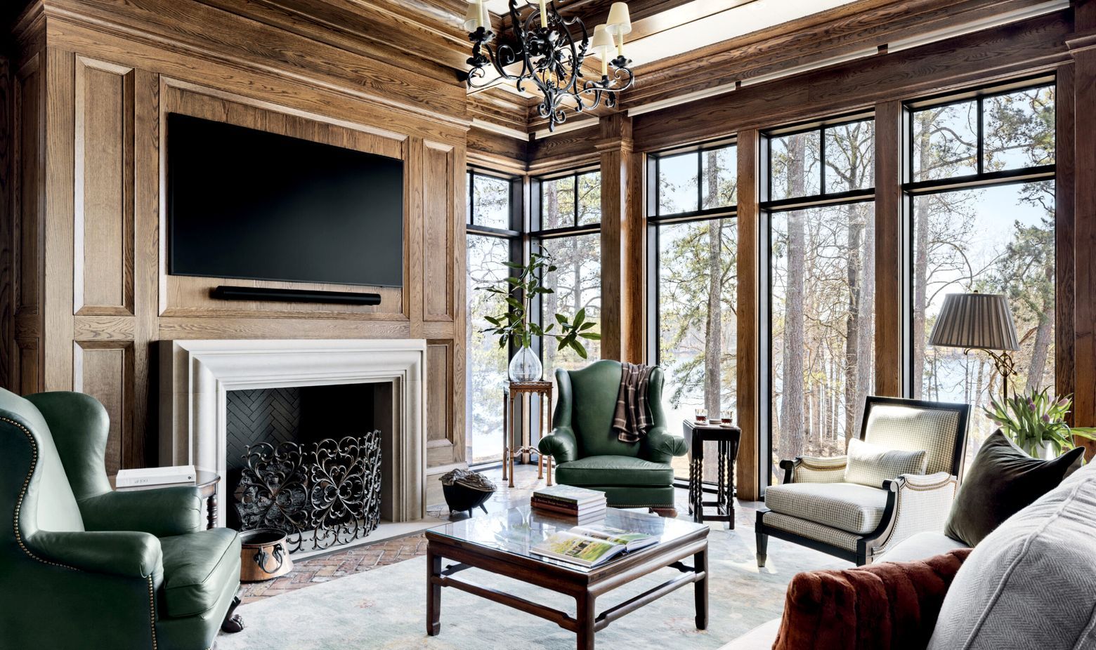An oak-panelled room with a limestone chimneypiece and full-height glazing to the water