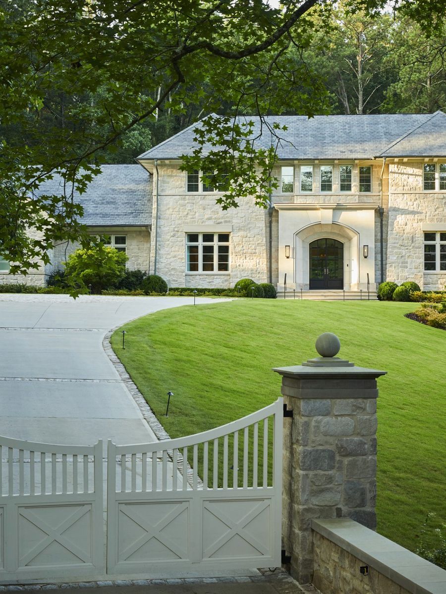 A stone residence seen from the gated approach